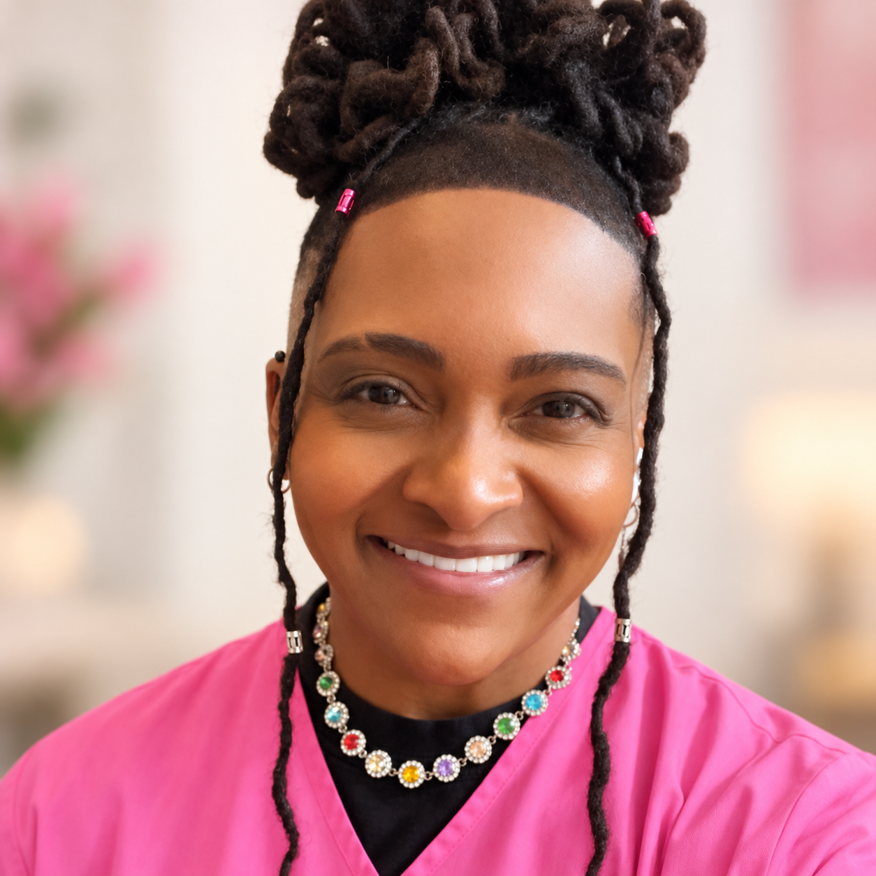 Passion Gibson, founder of Passion Centered Care Solutions, wearing pink scrubs
